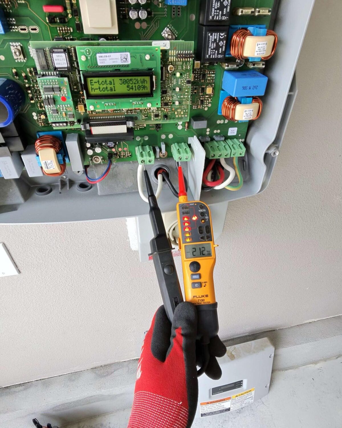 Solar inspector evaluating inverter and electrical equipment during a home inspection
